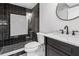 Modern bathroom with black and white tiling, contrasting finishes, and sleek fixtures for a spa-like experience at 5785 Timberlane Ter, Sandy Springs, GA 30328