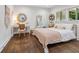 Cozy bedroom features hardwood floors, a metal frame bed, a round mirror, and natural light at 5785 Timberlane Ter, Sandy Springs, GA 30328