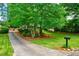 Long driveway leading to a charming home with lush green lawn and mature trees at 5785 Timberlane Ter, Sandy Springs, GA 30328
