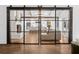 Open-concept space featuring a living room, white kitchen, fireplace, and black framed sliding doors at 5785 Timberlane Ter, Sandy Springs, GA 30328