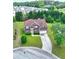 Aerial view of home boasting a well-manicured lawn, brick facade, a 2-car garage, and lush surrounding greenery at 1506 Saint George Pl, Conyers, GA 30012
