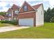 Side view of a two-story brick home with an attached two-car garage and a green lawn at 1506 Saint George Pl, Conyers, GA 30012