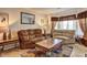 Inviting living room with patterned rug, love seat, side tables, mirror, and natural light streaming in at 1506 Saint George Pl, Conyers, GA 30012