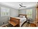 Well-lit bedroom with hardwood floors, white bedding, and modern ceiling fan at 4124 Dunnington Dr, Marietta, GA 30062