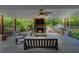 Covered patio with outdoor kitchen, stone fireplace, ceiling fan, and comfortable seating at 4124 Dunnington Dr, Marietta, GA 30062