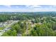 Aerial view of a suburban neighborhood with mature trees, green spaces, and a glimpse of a nearby lake at 5742 Harbor Dr, Buford, GA 30518