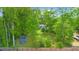 Aerial view of the spacious backyard with mature trees, outbuilding, and fenced perimeter at 5742 Harbor Dr, Buford, GA 30518