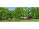 Well-maintained backyard featuring mature trees, lush green grass, and a charming wooden storage shed at 5742 Harbor Dr, Buford, GA 30518