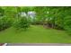 Large, well-maintained backyard with lush green grass and mature trees and additional structures at 5742 Harbor Dr, Buford, GA 30518