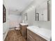Modern bathroom with double vanities, wood-look floors, and a shower-tub combo with neutral decor at 5742 Harbor Dr, Buford, GA 30518