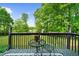 Cozy outdoor space with black metal patio furniture on a wooden deck overlooking a green lawn at 5742 Harbor Dr, Buford, GA 30518