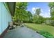 Outdoor deck with seating overlooks a green lawn with mature trees and blue skies at 5742 Harbor Dr, Buford, GA 30518