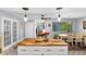 Open-concept dining area with a rustic table set, unique pendant lighting, and beautiful backyard views at 5742 Harbor Dr, Buford, GA 30518