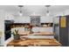 Well-lit kitchen featuring white cabinets, wooden countertops, stainless steel appliances, and modern pendant lights at 5742 Harbor Dr, Buford, GA 30518