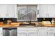 Well-lit kitchen with stainless steel appliances, contrasting wooden countertops, and black mosaic tile backsplash at 5742 Harbor Dr, Buford, GA 30518
