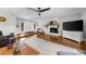Spacious living room with hardwood floors, a brick fireplace, a modern ceiling fan and ample natural light at 5742 Harbor Dr, Buford, GA 30518