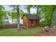Rustic shed in a landscaped yard with grassy area and mature trees, providing backyard storage at 5742 Harbor Dr, Buford, GA 30518