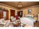 Serene bedroom with warm yellow walls, vintage furniture, and a comfortable seating area near the bed at 8612 Campbellton St, Douglasville, GA 30134