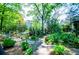 Lush garden pathway lined with plants, trees, and decorative white fencing at 8612 Campbellton St, Douglasville, GA 30134