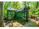 Quaint greenhouse with corrugated metal roof surrounded by greenery and natural light at 8612 Campbellton St, Douglasville, GA 30134