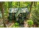 Greenhouse exterior featuring a tin roof and glass walls surrounded by flourishing vegetation at 8612 Campbellton St, Douglasville, GA 30134