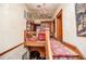 Charming hallway with a patterned rug, vintage cabinet, and staircase, bathed in soft, ambient light at 8612 Campbellton St, Douglasville, GA 30134
