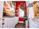 Compact kitchen with white cabinets, vintage fixtures, and bright red walls at 8612 Campbellton St, Douglasville, GA 30134
