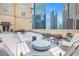 This rooftop patio offers comfortable seating and table, creating an ideal spot to enjoy city skyline views with friends at 1101 Juniper Ne St # 919, Atlanta, GA 30309