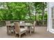 Outdoor deck with table and chairs, perfect for entertaining and enjoying views of the surrounding trees at 1161 Arborhill Dr, Woodstock, GA 30189