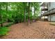 Spacious backyard features lush greenery, mature trees, and a charming play area at 1161 Arborhill Dr, Woodstock, GA 30189