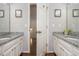 Dual vanity bathroom with granite countertops and an open doorway at 1161 Arborhill Dr, Woodstock, GA 30189