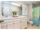 Well-lit bathroom with double sink vanity, large mirror, and shower/tub combo with bright floral shower curtain at 1161 Arborhill Dr, Woodstock, GA 30189