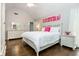 Bright bedroom features a white bed set and decorative art that complements the stylish design and hardwood floors at 1161 Arborhill Dr, Woodstock, GA 30189