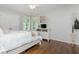 Bright bedroom featuring hardwood floors, a ceiling fan, and a white dresser beneath window at 1161 Arborhill Dr, Woodstock, GA 30189
