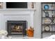 Close-up of a fireplace with a black screen and a wood holder on a painted brick fireplace at 1161 Arborhill Dr, Woodstock, GA 30189