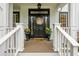 Inviting front door with a decorative wreath and matching flower pots on a charming wooden porch at 1161 Arborhill Dr, Woodstock, GA 30189