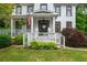 Charming two-story home with a welcoming front porch, American flag, and beautiful landscaping at 1161 Arborhill Dr, Woodstock, GA 30189
