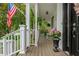 Covered porch features rocking chairs, hanging plants, and an American flag at 1161 Arborhill Dr, Woodstock, GA 30189
