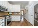 Kitchen featuring white cabinets, stainless steel appliances, and a view into an adjacent room at 1161 Arborhill Dr, Woodstock, GA 30189