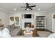 Bright living room features a fireplace with TV, hardwood floors, and French doors to the backyard at 1161 Arborhill Dr, Woodstock, GA 30189