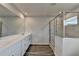 Bathroom showcasing a dual sink vanity and a glass-enclosed shower with tile surround at 3968 Annsbury Court, Lilburn, GA 30047
