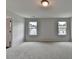 Bright bedroom with abundant natural light, plush carpeting, and a view of neighboring homes through two large windows at 3968 Annsbury Court, Lilburn, GA 30047