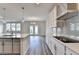 Open kitchen with an island, stainless steel appliances, and hardwood floors leading to a bright dining area at 3968 Annsbury Court, Lilburn, GA 30047