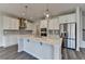 Modern kitchen with stainless steel appliances, a kitchen island, and stylish pendant lighting above at 3968 Annsbury Court, Lilburn, GA 30047