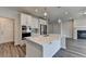 Kitchen with an island, stainless steel appliances, and hardwood floors, adjacent to a fireplace in the living area at 3968 Annsbury Court, Lilburn, GA 30047