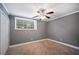 Cozy bedroom features soft carpeting, a ceiling fan, a window, and a closet for storage at 5400 Roswell Rd # L-3, Atlanta, GA 30342