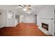 Living room featuring a fireplace, hardwood floors, a ceiling fan, and opening to a kitchen bar at 5400 Roswell Rd # L-3, Atlanta, GA 30342