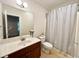 Bathroom featuring a single sink vanity, toilet, and shower with gray shower curtain at 702 Emeril Dr, Avondale Estates, GA 30002
