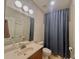 Bathroom featuring a single sink vanity, toilet, and shower with blue shower curtain at 702 Emeril Dr, Avondale Estates, GA 30002