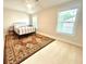 Bright bedroom features a decorative rug, lots of natural light from the windows, and a comfy bed at 702 Emeril Dr, Avondale Estates, GA 30002